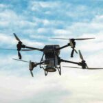 Large agricultural drone in flight over a sown field